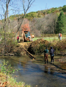 Watershed staff installs a multilog
vane deflector in Tubmill Creek,
used for erosion control and
creation of fish habitat.